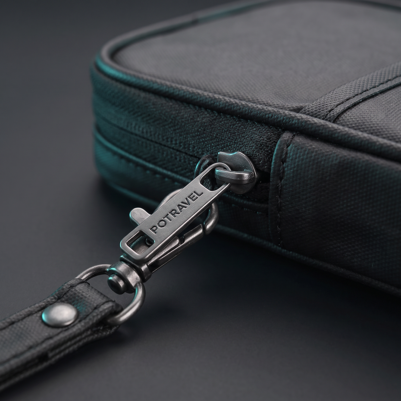 Pochette de voyage Voyra — détail zip, dragonne et coutures